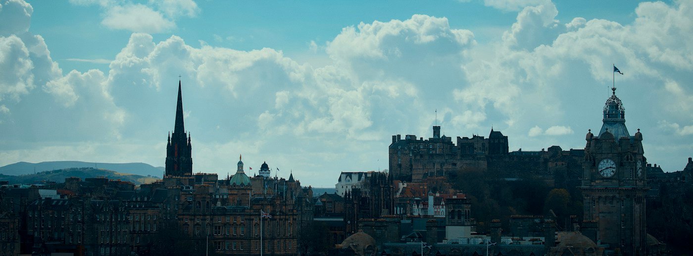 Edinburgh Castle and the historic city skyline beneath a dramatic cloud-filled sky